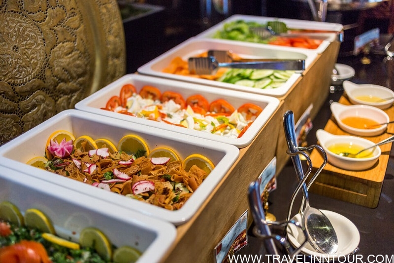 Buffet with various Middle Eastern salads including tabbouleh, fattoush, and sliced vegetables, showcasing traditional Dubai culinary experiences.