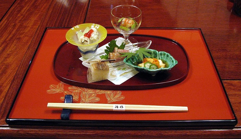 Traditional Kyoto kaiseki meal displayed on a lacquered tray featuring a variety of artistically arranged small dishes, showcasing the elegance of Japanese cuisine. Perfect for experiencing local culture on a 2-day Kyoto itinerary.
