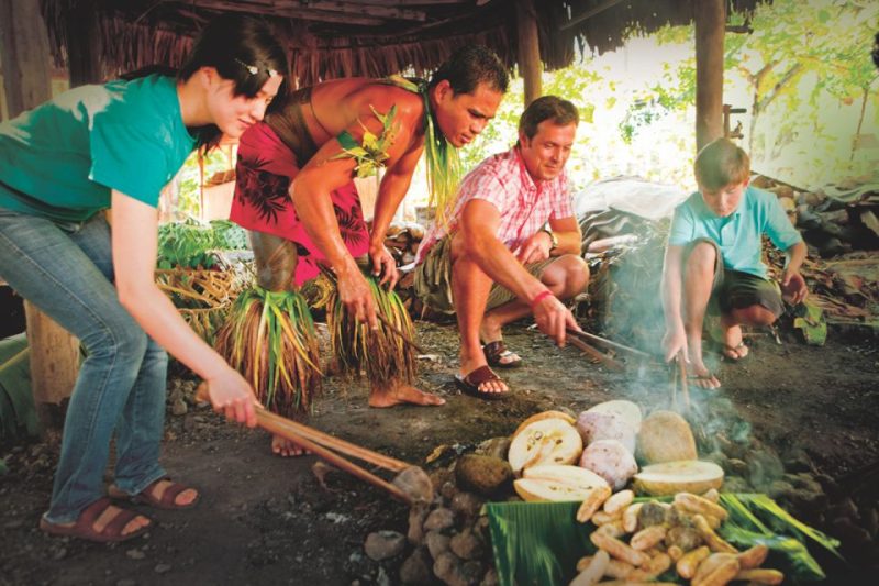 Traditional Hawaiian cooking demonstration in Kona, Hawaii, showing people learning local culinary techniques with a cultural expert.