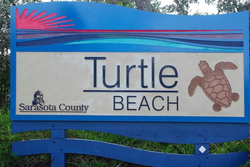 Sign for Turtle Beach in Sarasota County, Florida, featuring a turtle illustration and beach theme, highlighting family-friendly beach spots in Sarasota.